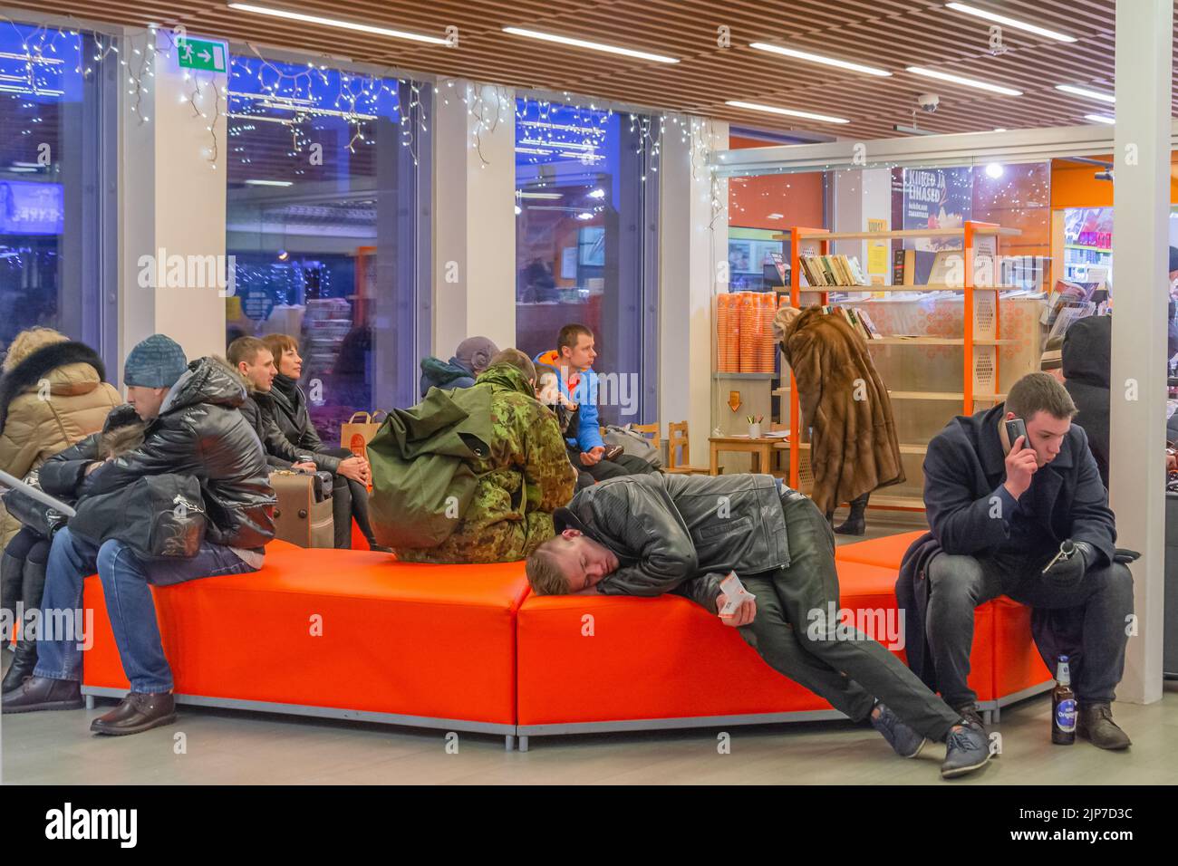 Homme dormant sur un canapé avec tickets de bus à la gare routière de Bussijaam à Tallinn, Estonie Banque D'Images