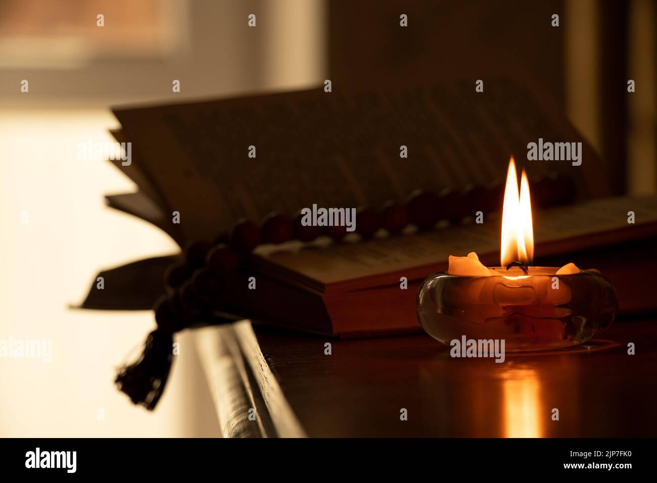 La Bible et le rosaire se trouvent sur la table près de la flamme à la maison, la prière et la bible, la foi et la religion Banque D'Images