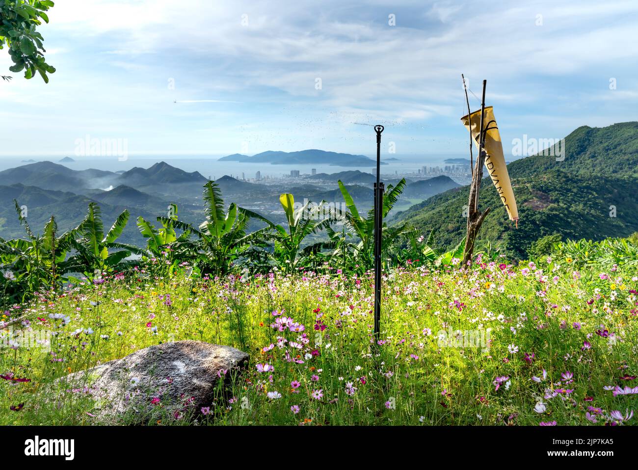 Un petit jardin fleuri de l'homestay est situé au milieu de la forêt de haute montagne. De là, regardez la célèbre ville touristique côtière de Banque D'Images