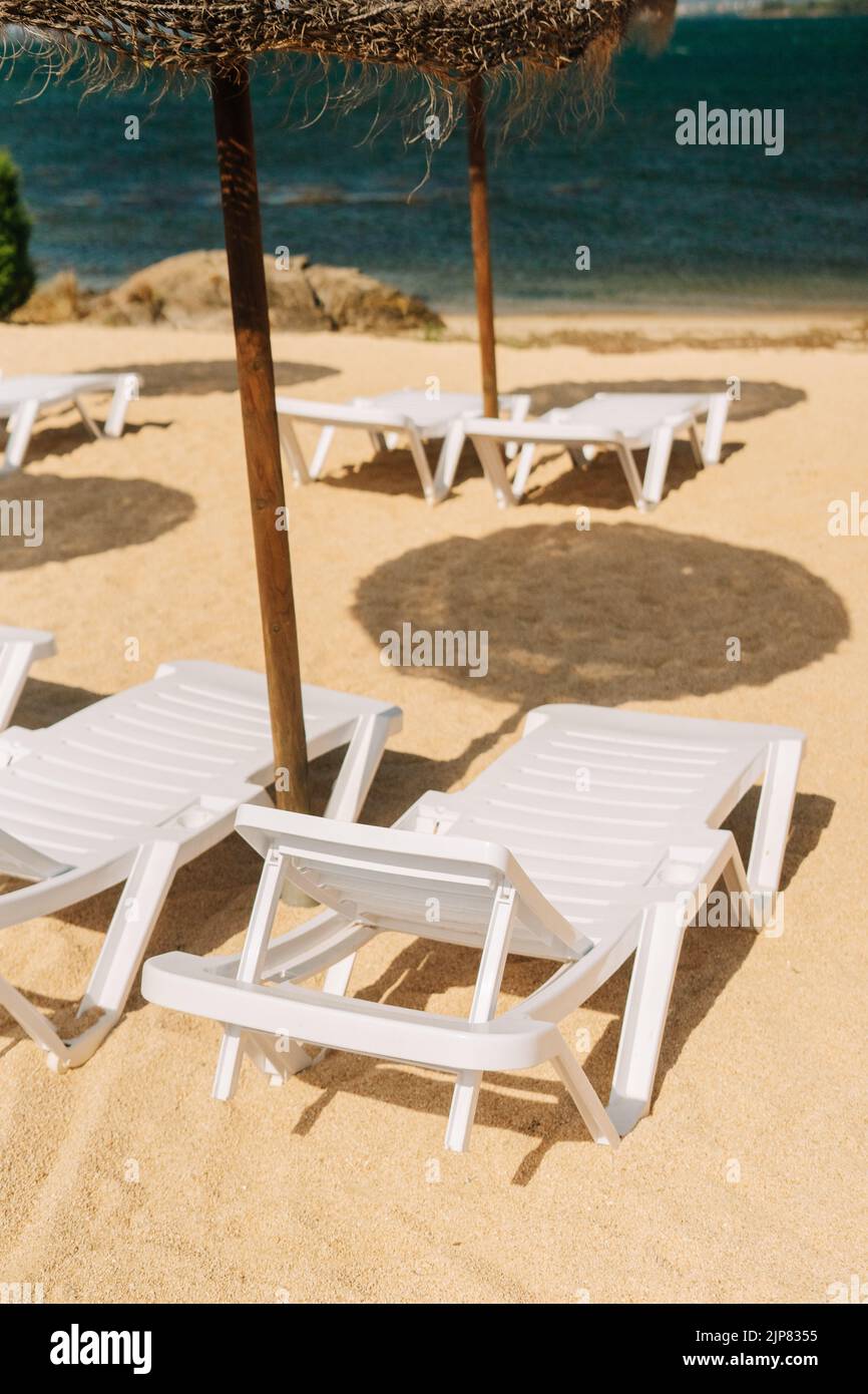 Détail des chaises longues avec parasols en paille près de la rivière en Galice, Espagne Banque D'Images