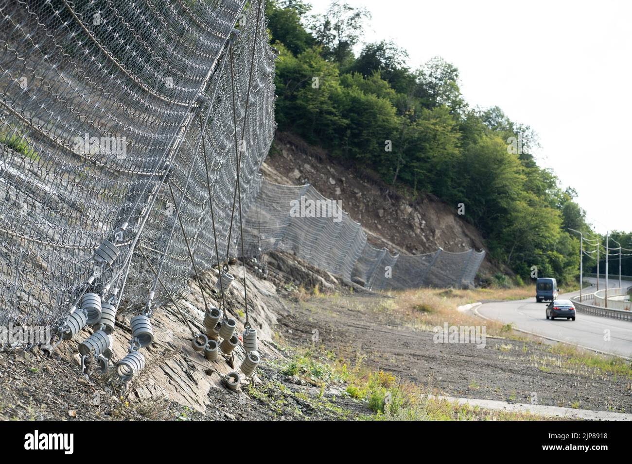 Système de barrière contre les chutes de pierres robuste actif avec treillis métallique le long de la route, frein pour les chutes de pierres. Banque D'Images