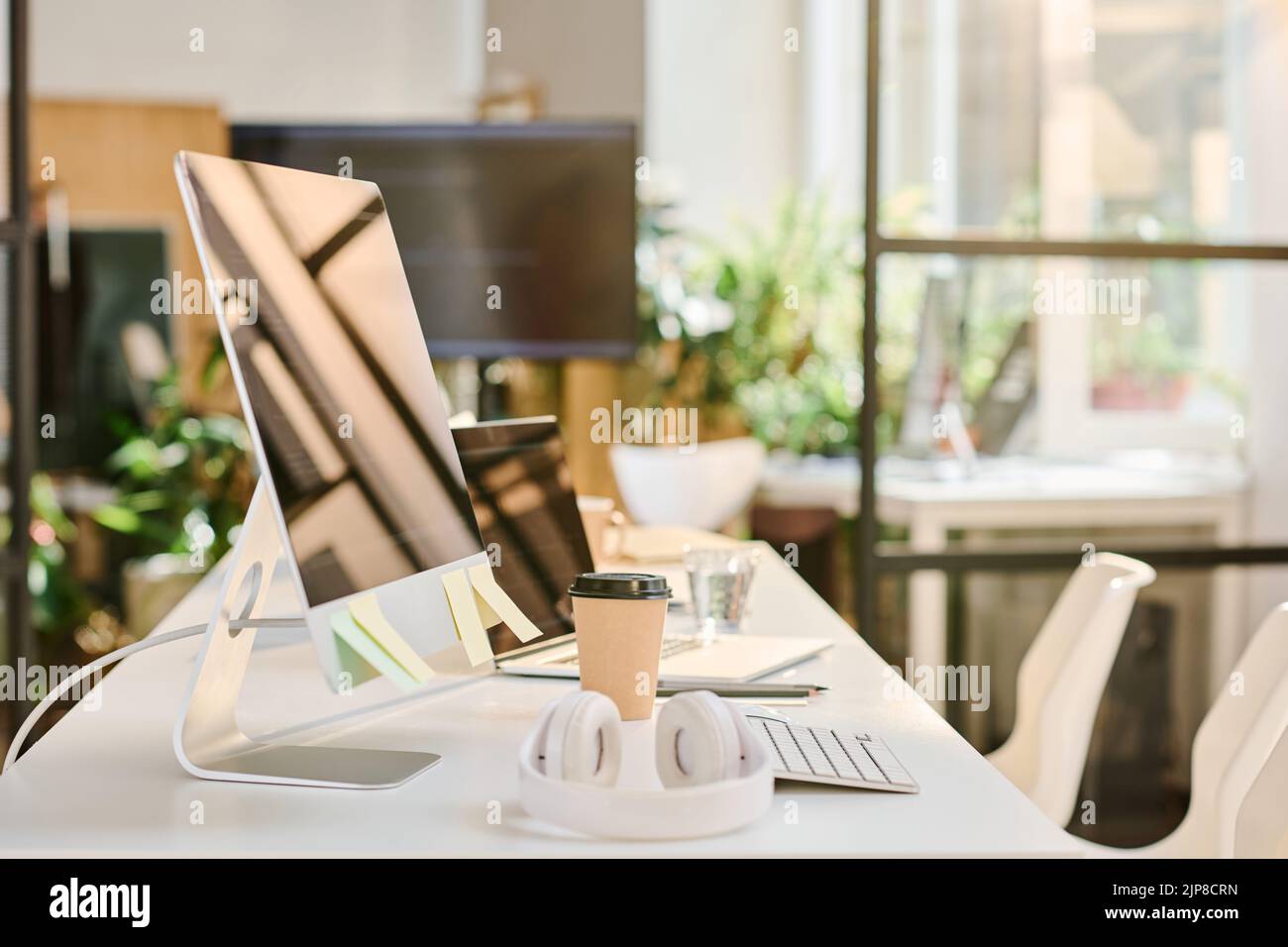 Image horizontale du lieu de travail du programmeur au bureau avec ordinateur, casque et boisson à base de café Banque D'Images