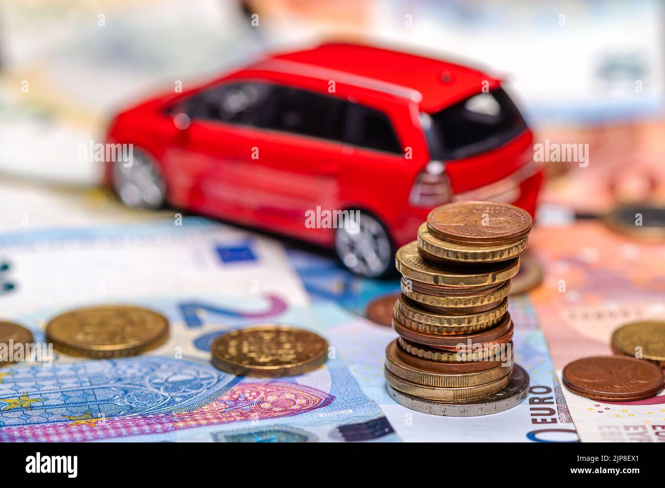 Tour avec pièces en euros sur le fond des billets et de la voiture de jouet rouge, prêt et concept d'assurance Banque D'Images