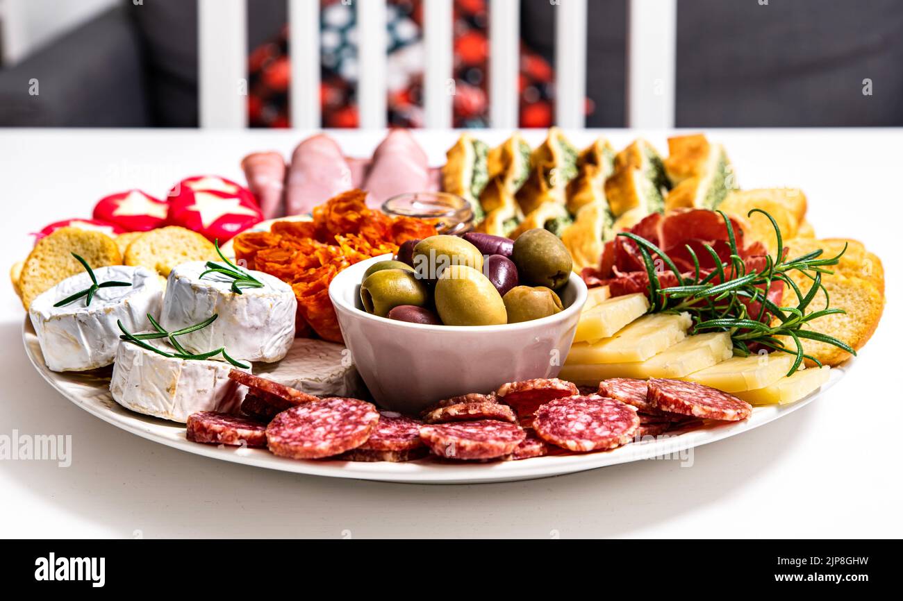 La cuisine italienne montre un repas accueillant : délicieux plat au pepperoni, au jambon de crudo, au fromage de brie, au salami, à la confiture et au pain de focaccia accompagnés de salami et d'olives Banque D'Images