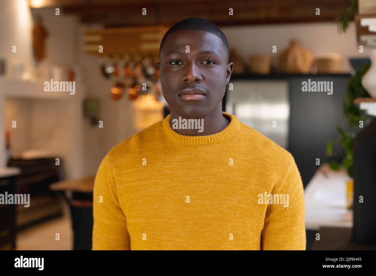 Portrait de l'homme afro-américain debout dans la cuisine à la maison regardant directement à l'appareil photo Banque D'Images