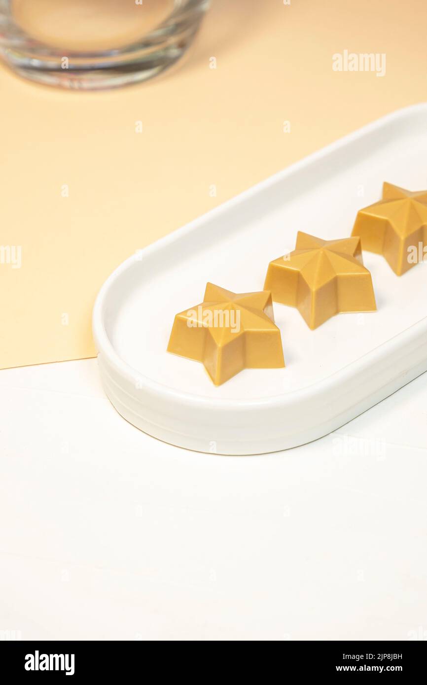 Chocolat fait main en forme d'étoile sur une assiette blanche. Produits chocolatiers faits main. Banque D'Images