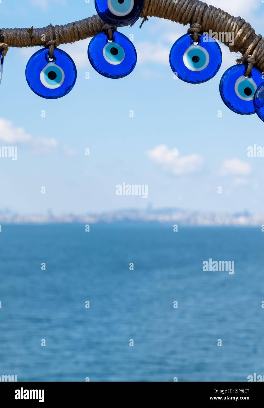 Perles oeil mauvais gros plan sur fond de mer. Perles de Nazar. Souvenir touristique turc Banque D'Images
