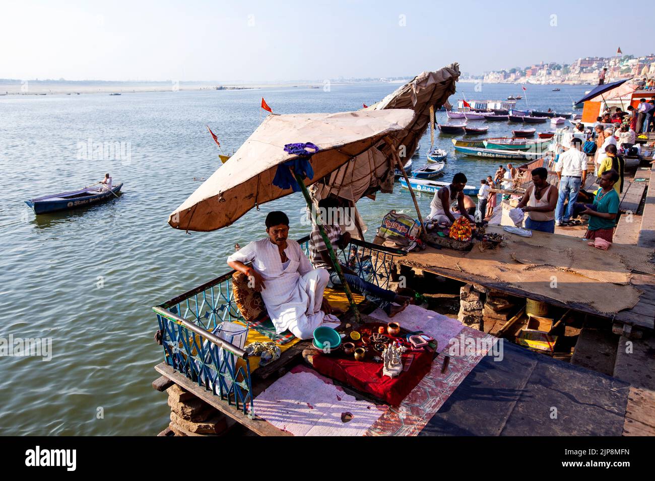 Prêtre assis sous un immense parapluie à Dashashwamedh Ghat sur le Gange du Ganga, Varanasi, Banaras, Benaras, Kashi, Uttar Pradesh, Inde Banque D'Images