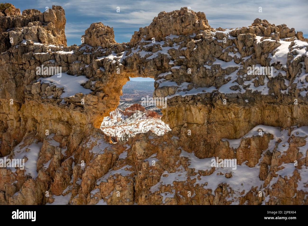 Les oodoos sont visibles à travers une fenêtre d'arche d'Un mur couvert de neige dans le parc national de Bryce Canyon Banque D'Images