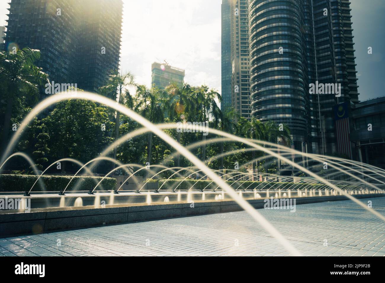 Kuala Lumpur, Malaisie - 13 août 2022: Le parc KLCC avec le spectacle de la fontaine en face des tours Petronas. Exposition longue avec de l'eau soyeuse j Banque D'Images