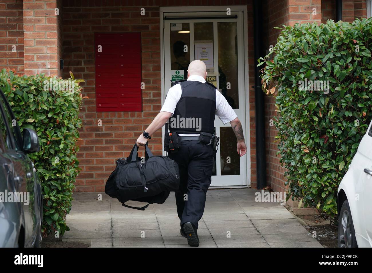 Un policier est entré sur les lieux du Cléariat court à Boddington Gardens, Ealing, dans l'ouest de Londres, où une femme de 58 ans a été poignardée à mort lundi. Une femme de 21 ans, qui a été hospitalisée pour une blessure non mortelle avant d'être transférée à la garde à vue, a été arrêtée pour suspicion de meurtre. Date de la photo: Mardi 16 août 2022. Banque D'Images