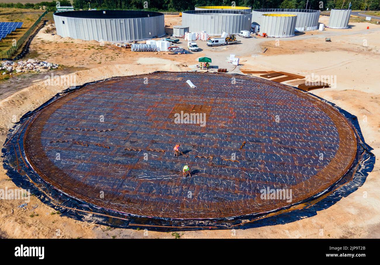 16 août 2022, Mecklembourg-Poméranie occidentale, Torgelow: Les travailleurs posent de l'acier de renforcement pour la fondation d'un autre grand réservoir, de plus de 30 mètres de diamètre, pour la future usine de biogaz. (Photographie aérienne prise avec un drone). L'usine fournira 15 000 habitants de la ville de Torgelow. L'usine de Mele Biogas, qui compte actuellement six réservoirs de stockage, sera élargie pour doubler sa capacité d'ici l'automne 2023. Selon l'Association d'État de Mecklembourg-Poméranie occidentale pour l'énergie renouvelable, un volume d'énergie de plus de 100 millions de kilowattheures par an sera produit ici et aussi Banque D'Images