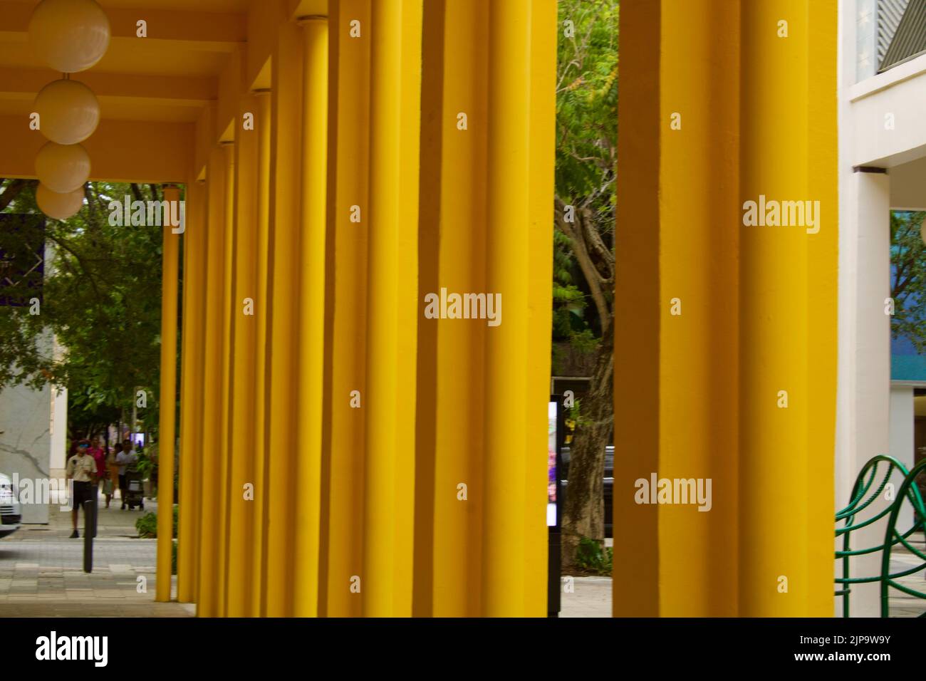 Colonnes structurelles jaunes vibrantes menant à la rue. Banque D'Images
