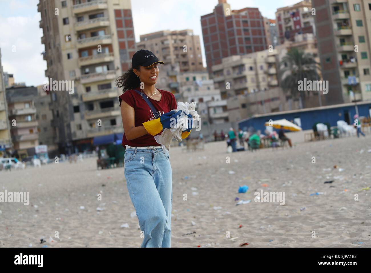 (220816) -- ALEXANDRIE, 16 août 2022 (Xinhua) -- Une femme recueille des déchets de la plage d'Alexandrie, Égypte, 13 août 2022. Sur les plages de la ville égyptienne d'Alexandrie, un groupe de jeunes égyptiens sont généralement vus tenant des sacs en plastique vert et blanc pour recueillir les déchets de dispersion. Ils participent à une campagne de nettoyage organisée par Banlastic Egypt, un projet environnemental lancé par un groupe de jeunes de la ville méditerranéenne. Le projet vise à sensibiliser le public à la pollution par le plastique et à la façon dont les déchets de plastique à usage unique nuisent à la vie marine s'ils finissent par se terminer Banque D'Images