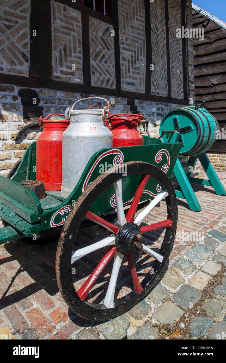 Chariot à main ancien chargé de quatre vieux cannes à lait en métal / boîtes à lait et de tonneau de beurre de type tonneau en bois vintage Banque D'Images