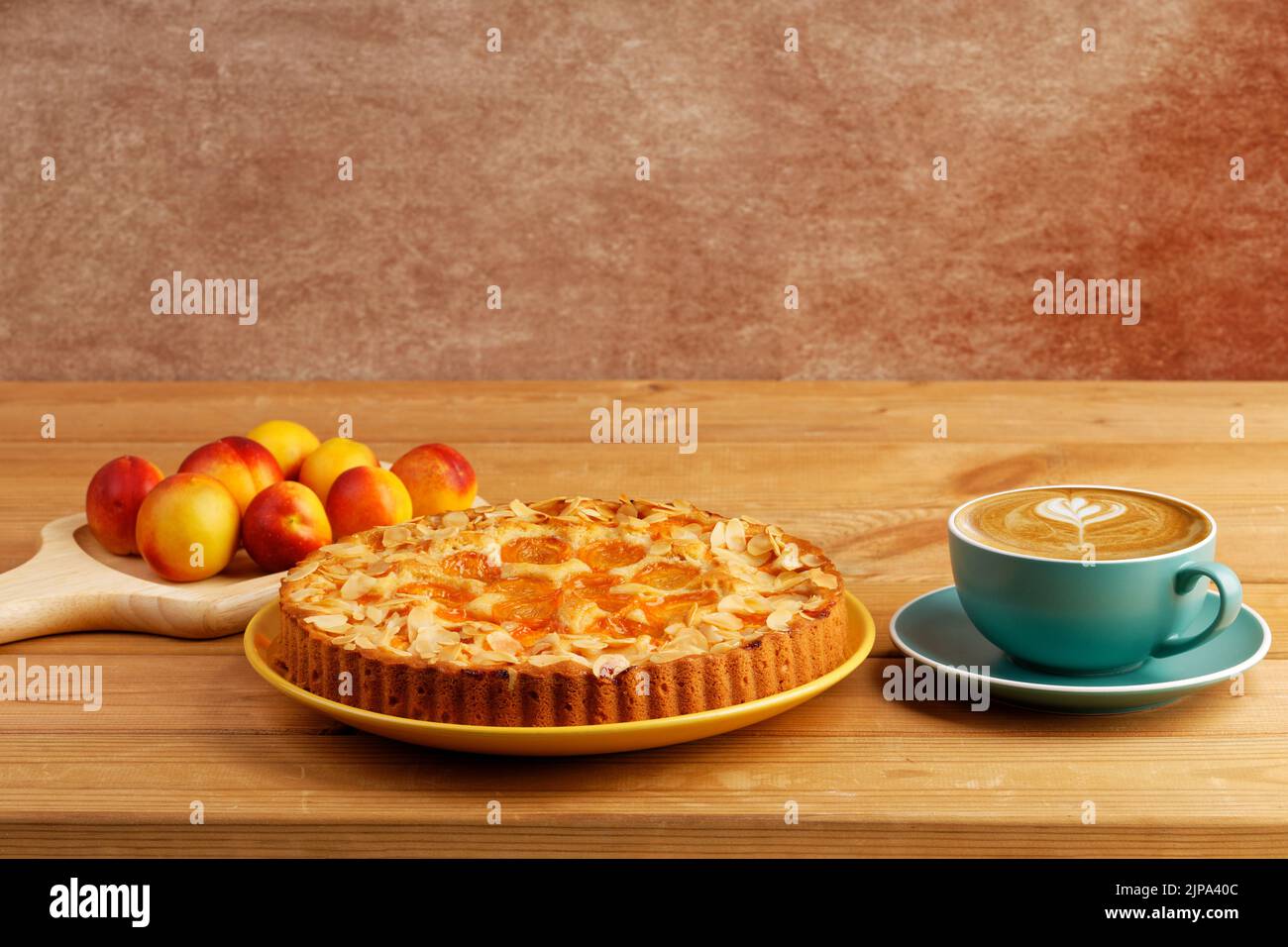 Tarte maison aux abricots et une tasse de café cappuccino sur une table en bois. CopySpace. Banque D'Images Tarte maison aux abricots et une tasse de café cappuccino sur une table en bois. CopySpace. Banque D'Images