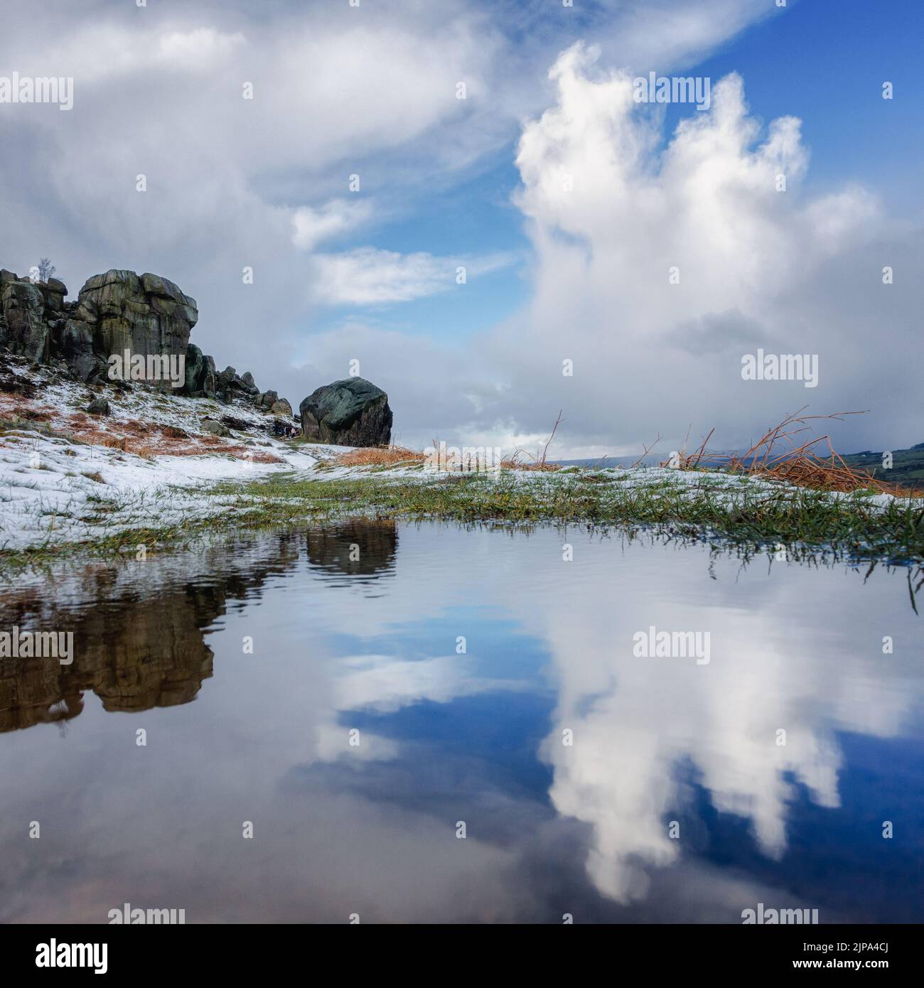 Vue inhabituelle sur les rochers de Cow et de Calf sur la lande d'Ilkley par temps neigeux, revisite dans une flaque, West Yorkshire, Angleterre, Royaume-Uni Banque D'Images