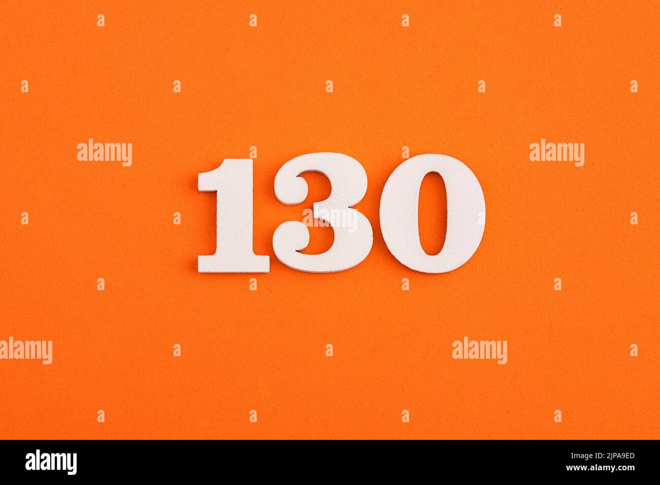 En bois blanc numéro 130 sur fond orange en caoutchouc eva Banque D'Images