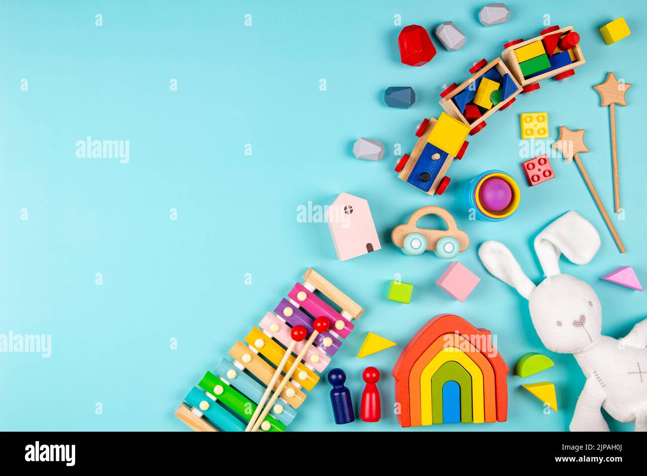 Jouets pour enfants sur fond bleu clair. Jouets éducatifs en bois et musicaux colorés. Vue de dessus, plan d'appartement Banque D'Images