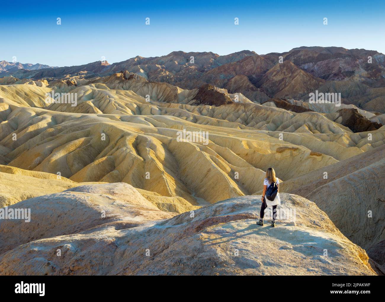 Randonneur admirant la merveille naturelle de la Bad Lands Zabriskie point, parc national de la Vallée de la mort, Californie, Amérique du Nord, États-Unis Banque D'Images