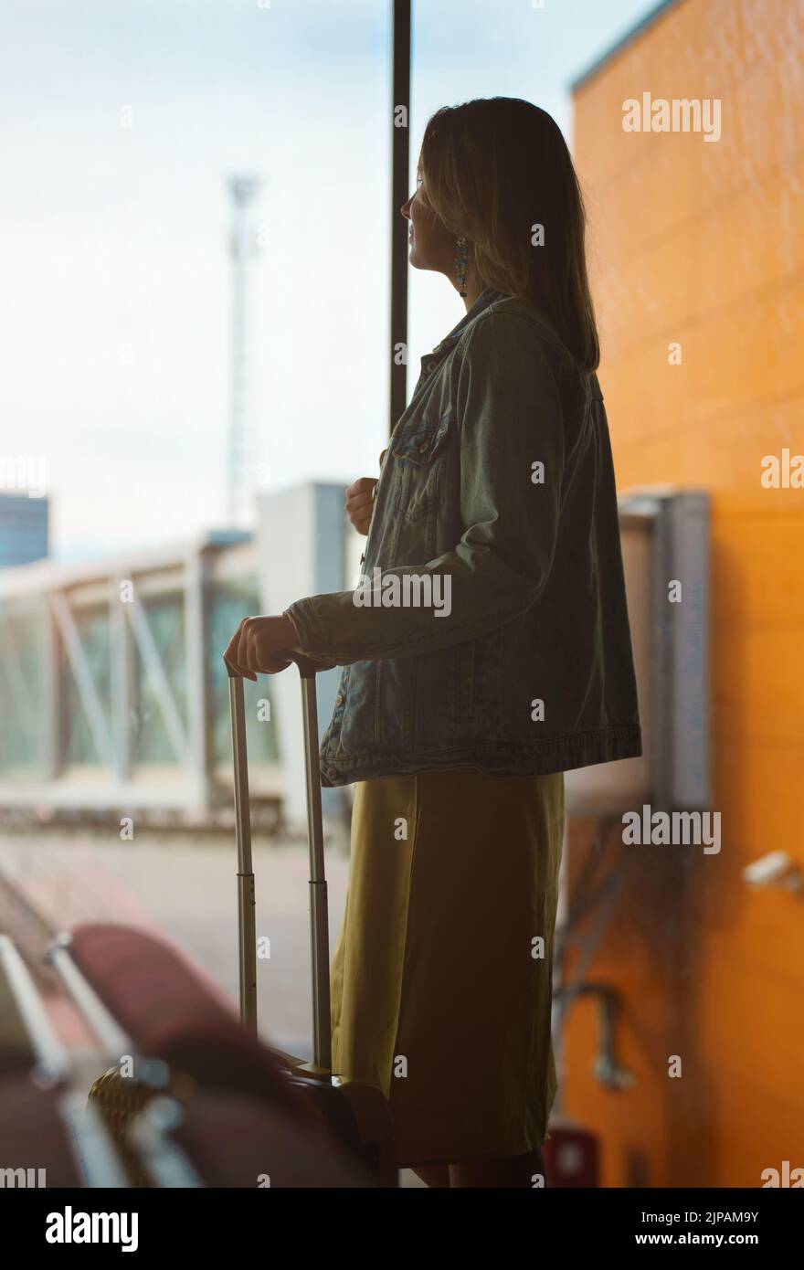 Femme avec bagages attendant le vol à l'aéroport. Banque D'Images
