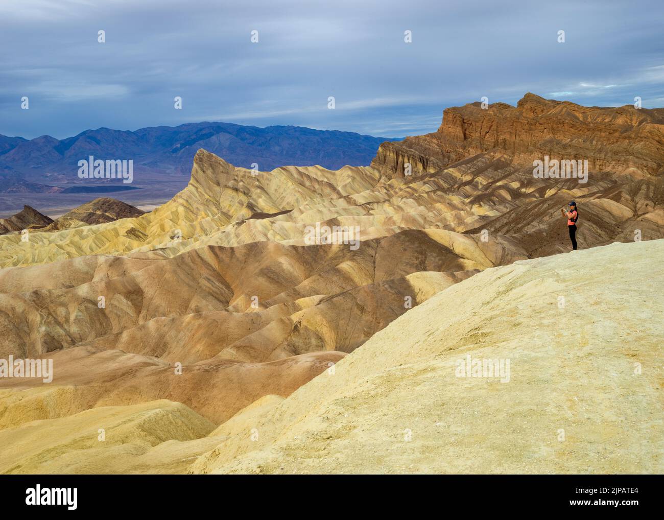 Randonneur admirant les merveilles naturelles des mauvaises terres colorées, Zabriskie point, parc national de la Vallée de la mort, Californie, Amérique du Nord, États-Unis Banque D'Images