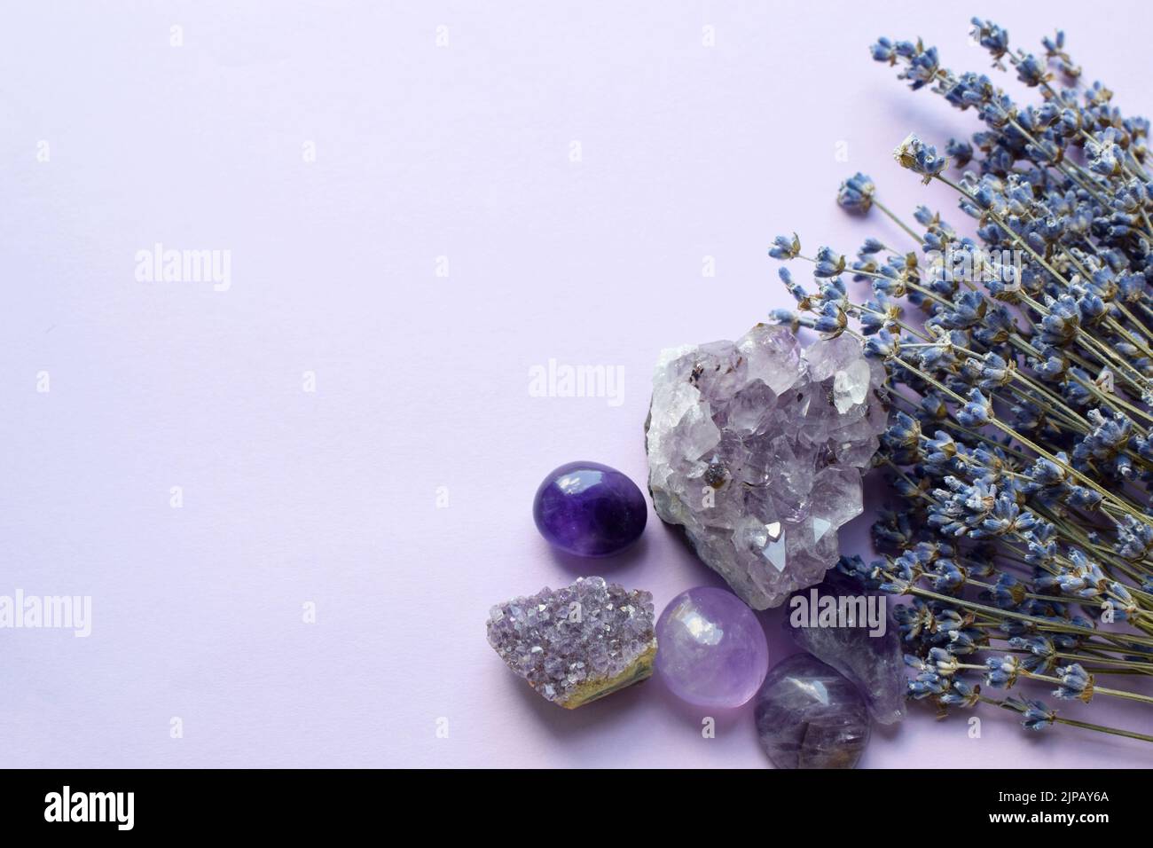 Belles pierres améthystes et druze améthyste avec un bouquet sec de lavande sur fond lilas. Amulettes magiques. Espace de copie Banque D'Images