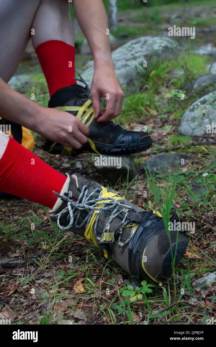 vue de bottes de randonnée déchirées sur les pieds d'une personne, un touriste, sur laquelle il a blessé un ruban isolant Banque D'Images