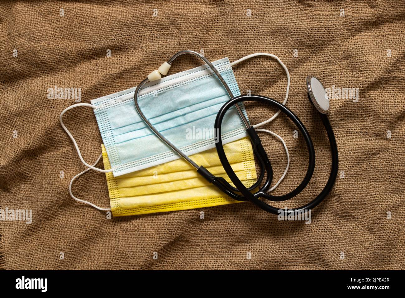 Masques médicaux jaunes et bleus comme le drapeau de l'Ukraine et un stéthoscope sur la table. Drapeau d'Etat de l'Ukraine, arrêter la guerre. La Russie est l'agresseur Banque D'Images