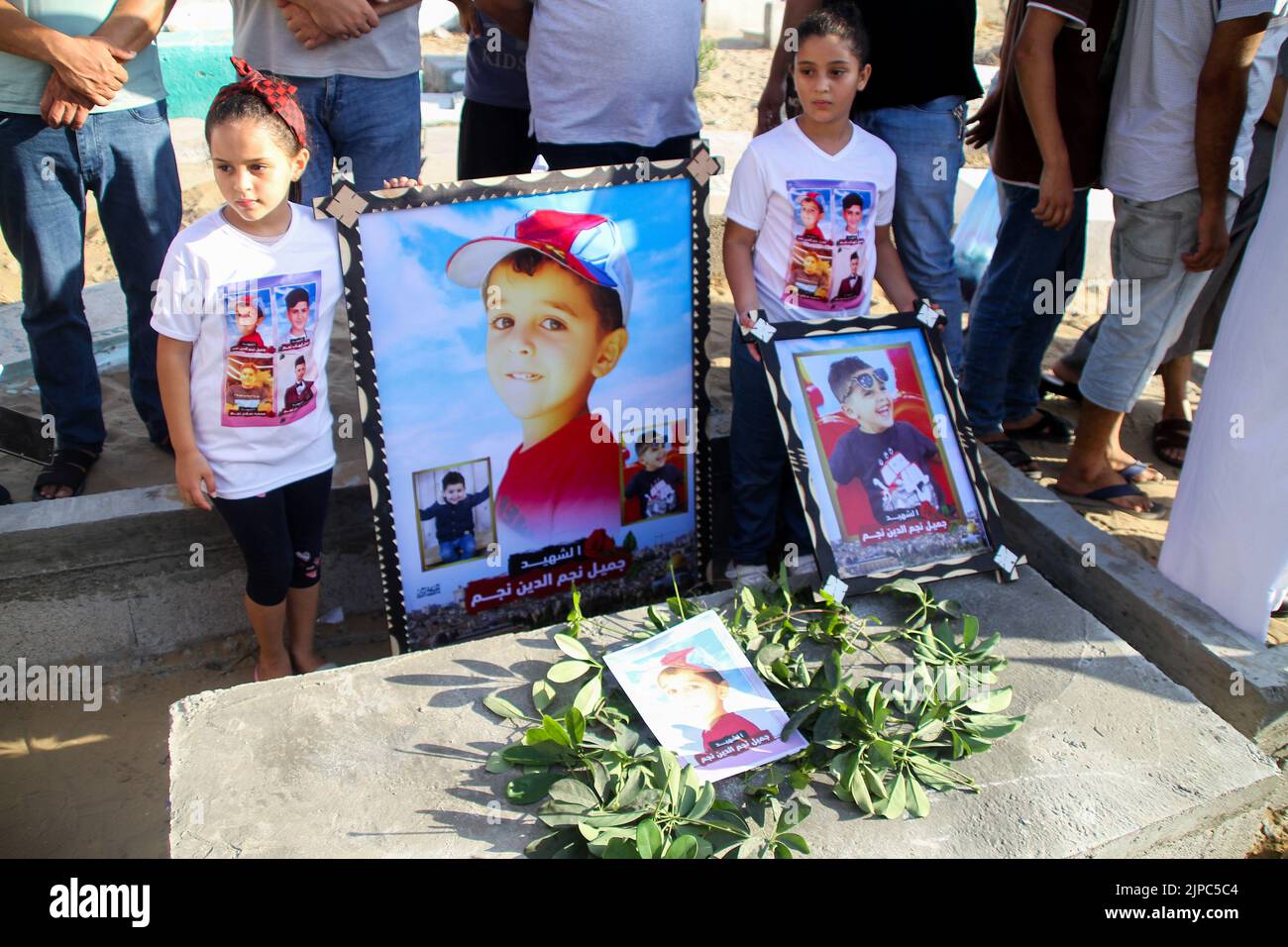 Jabalia, bande de Gaza, Palestine. 16th août 2022. Gaza, Palestine. 16 août 2022. Les Palestiniens tiennent une veillée dans le cimetière d'Al Fallujah près du camp de réfugiés de Jabalia, dans le nord de la bande de Gaza. Des enfants ont tenu des banderoles réclamant la protection des enfants, sur le site où 5 enfants de la famille Najm ont été tués lors de la dernière offensive israélienne sur Gaza. Cette vigile fait suite à l'admission de responsables israéliens que cinq enfants ont été tués lors d'une attaque aérienne israélienne contre le cimetière d'Al-Fallujah, à l'ouest du camp de réfugiés de Jabalia, dans le nord de la bande de Gaza, le 7th août (Credit image: © Ahmad Hasaballah Banque D'Images