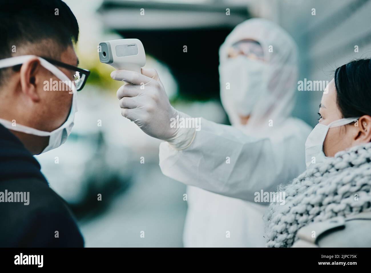 Un professionnel de la santé teste la température des covid pour vérifier les protocoles, la conformité ou les restrictions de pays dans un aéroport ou une frontière. Personnes voyageant à l'étranger avec Banque D'Images Un professionnel de la santé teste la température des covid pour vérifier les protocoles, la conformité ou les restrictions de pays dans un aéroport ou une frontière. Personnes voyageant à l'étranger avec Banque D'Images
