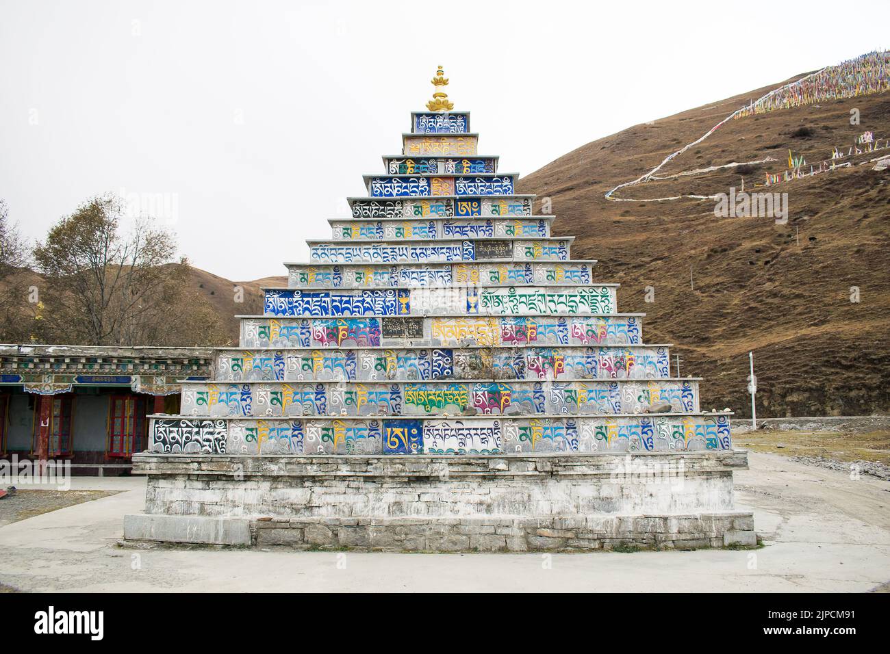 Stupa Tibétain en forme de pyramide faite de dalles de pierre colorées, imprimé avec écriture bouddhiste en langue tibétaine standard, monastère de Tagong. Banque D'Images