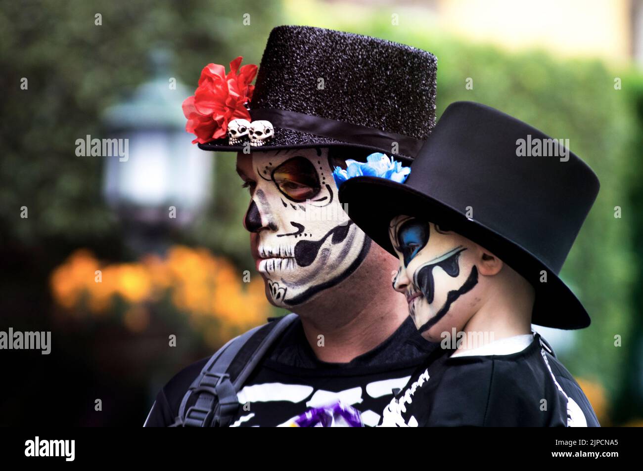 Gros plan d'un homme tenant un enfant avec un maquillage peint du crâne célébrant le jour de la mort Banque D'Images