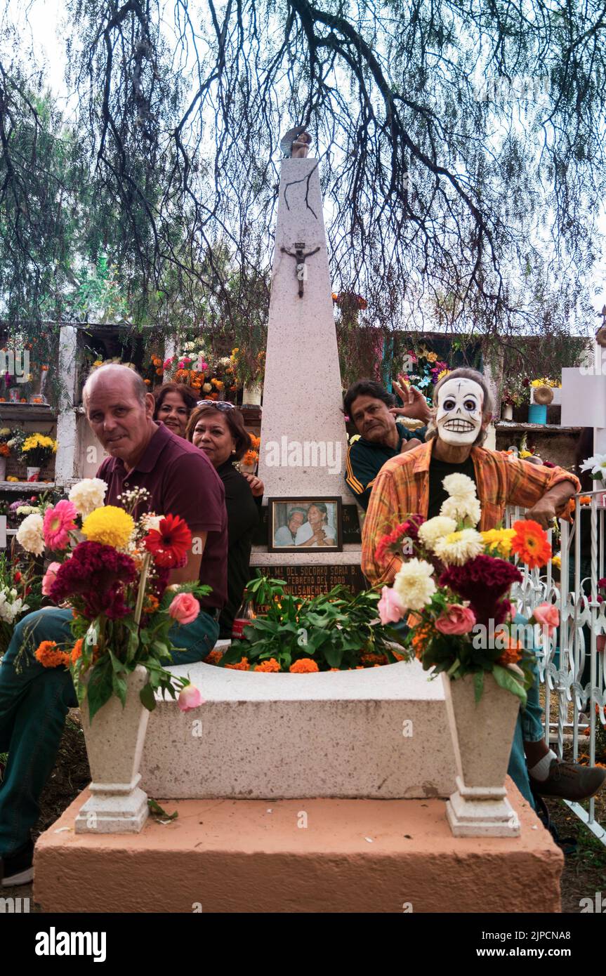 Un cliché vertical de personnes aux visages peints célébrant le jour de la mort dans le cimetière Banque D'Images