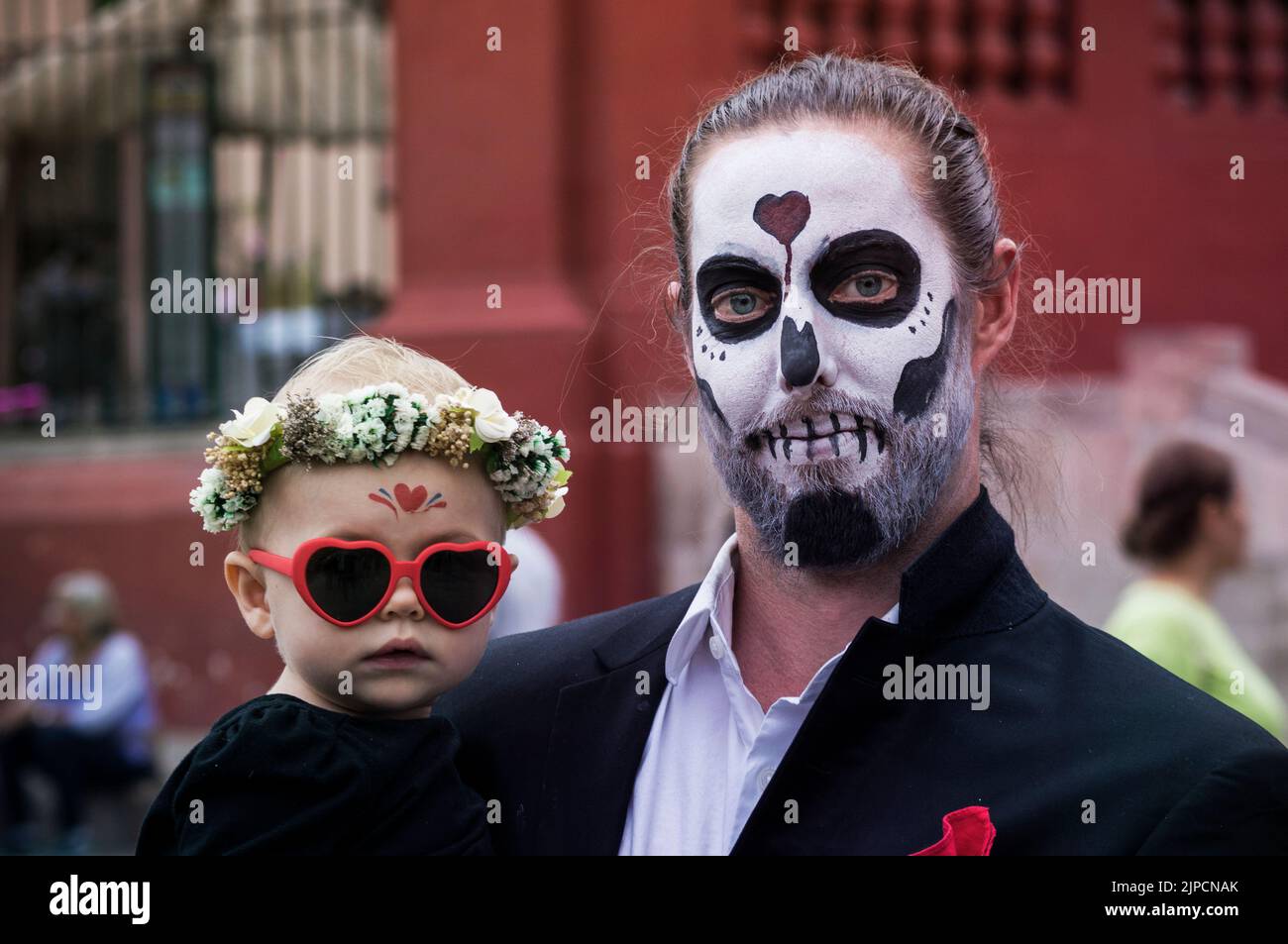 Gros plan d'un homme tenant son bébé avec des visages peints célébrant le jour de la mort Banque D'Images