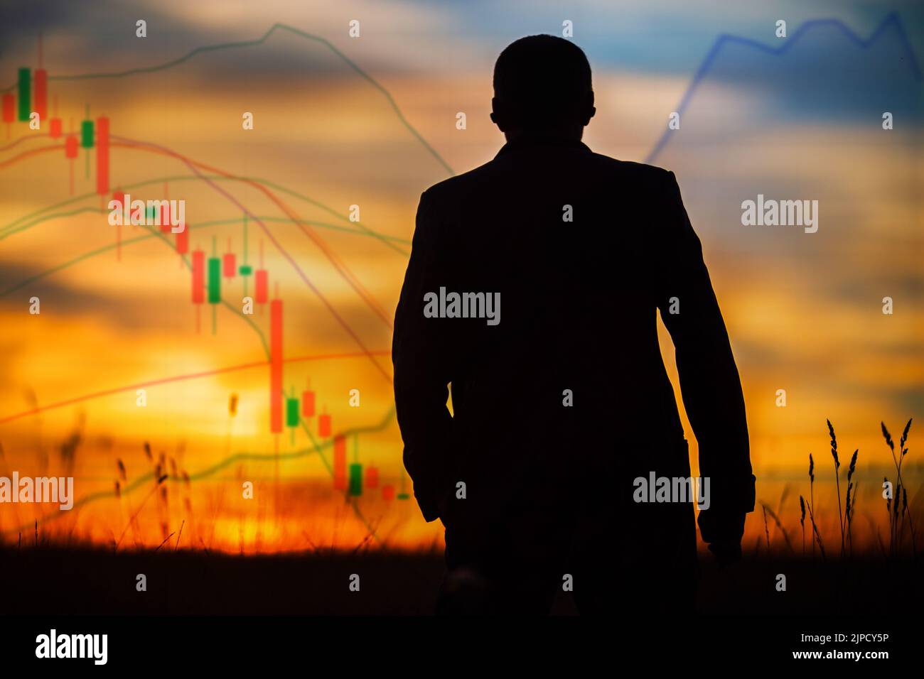 Silhouette d'un homme regardant les cartes du marché boursier au coucher du soleil. Investisseur professionnel, commerçant. Nouvelle crise financière économique à venir. Manipulateur de marché Banque D'Images