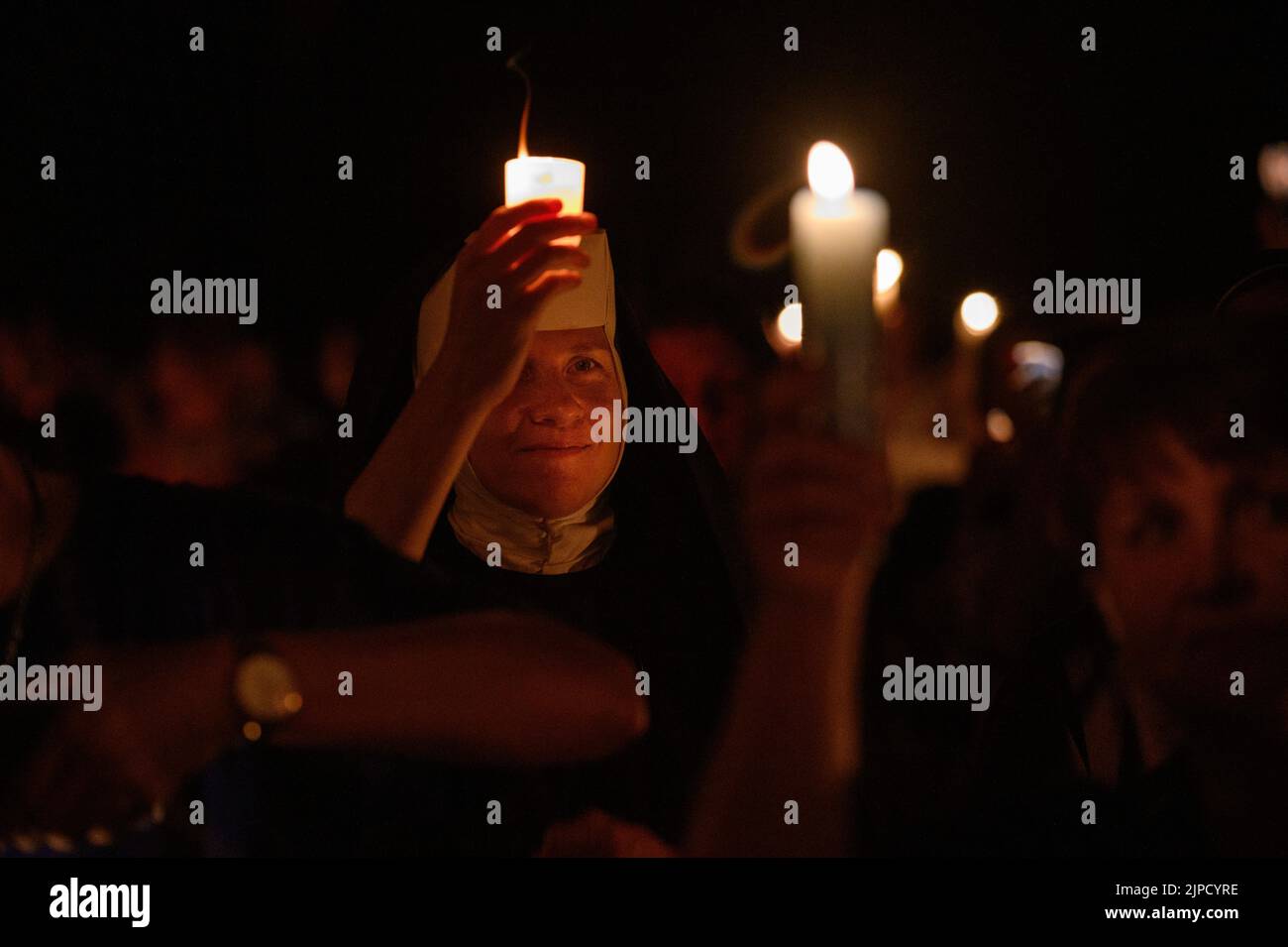 Des gens aux bougies priant et chantant pendant la vénération de la Sainte Croix après la Messe pendant Mladifest (Festival de la Jeunesse) à Medjugorje. Banque D'Images