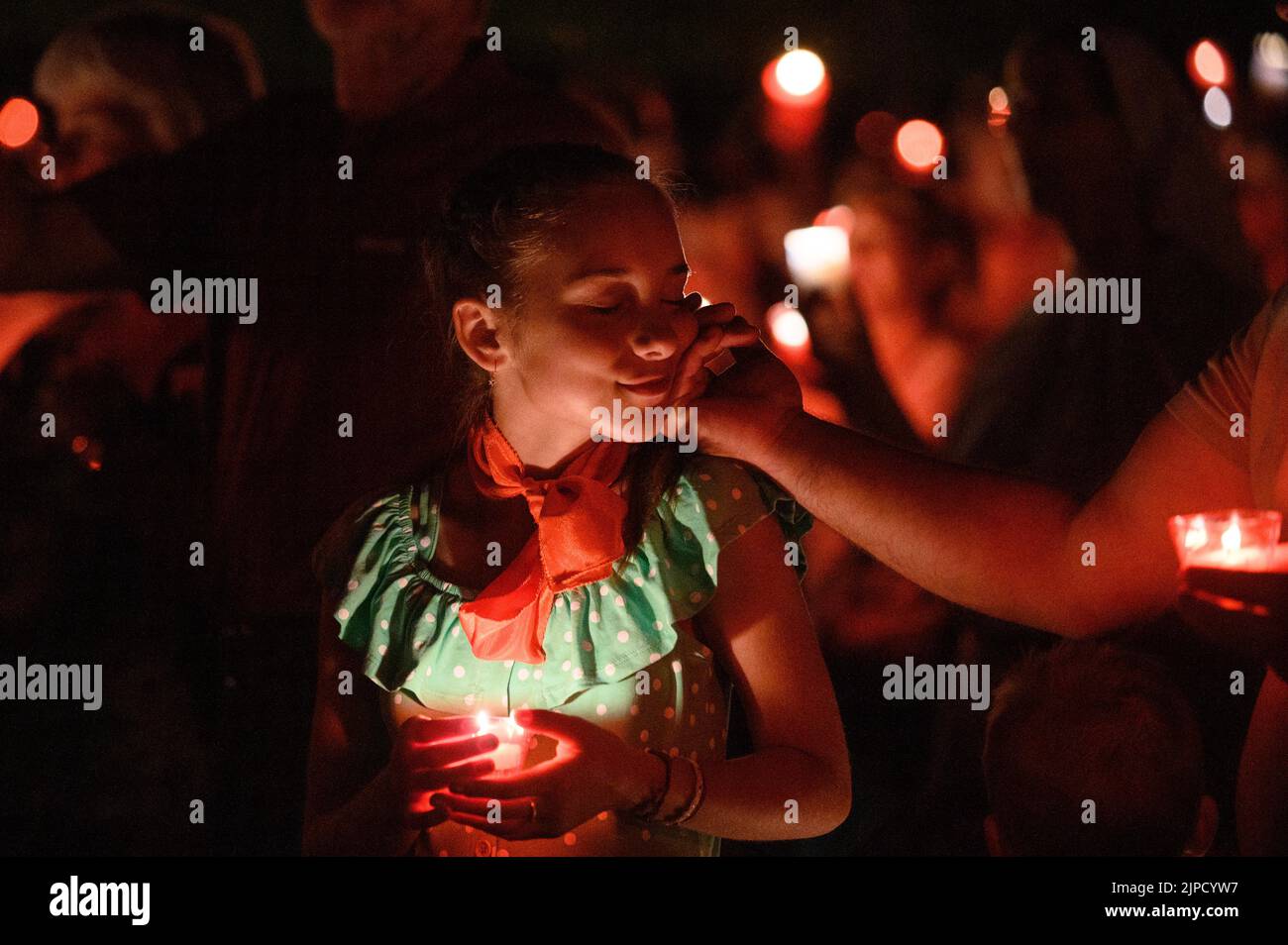 Des gens aux bougies priant et chantant pendant la vénération de la Sainte Croix après la Messe pendant Mladifest (Festival de la Jeunesse) à Medjugorje. Banque D'Images