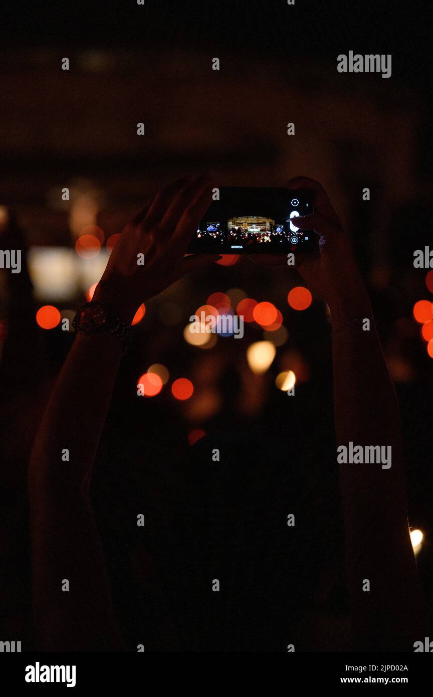 Quelqu'un prenant une photo avec un téléphone pendant la vénération de la Sainte Croix après la Messe pendant Mladifest (Festival de la Jeunesse) à Medjugorje. Banque D'Images