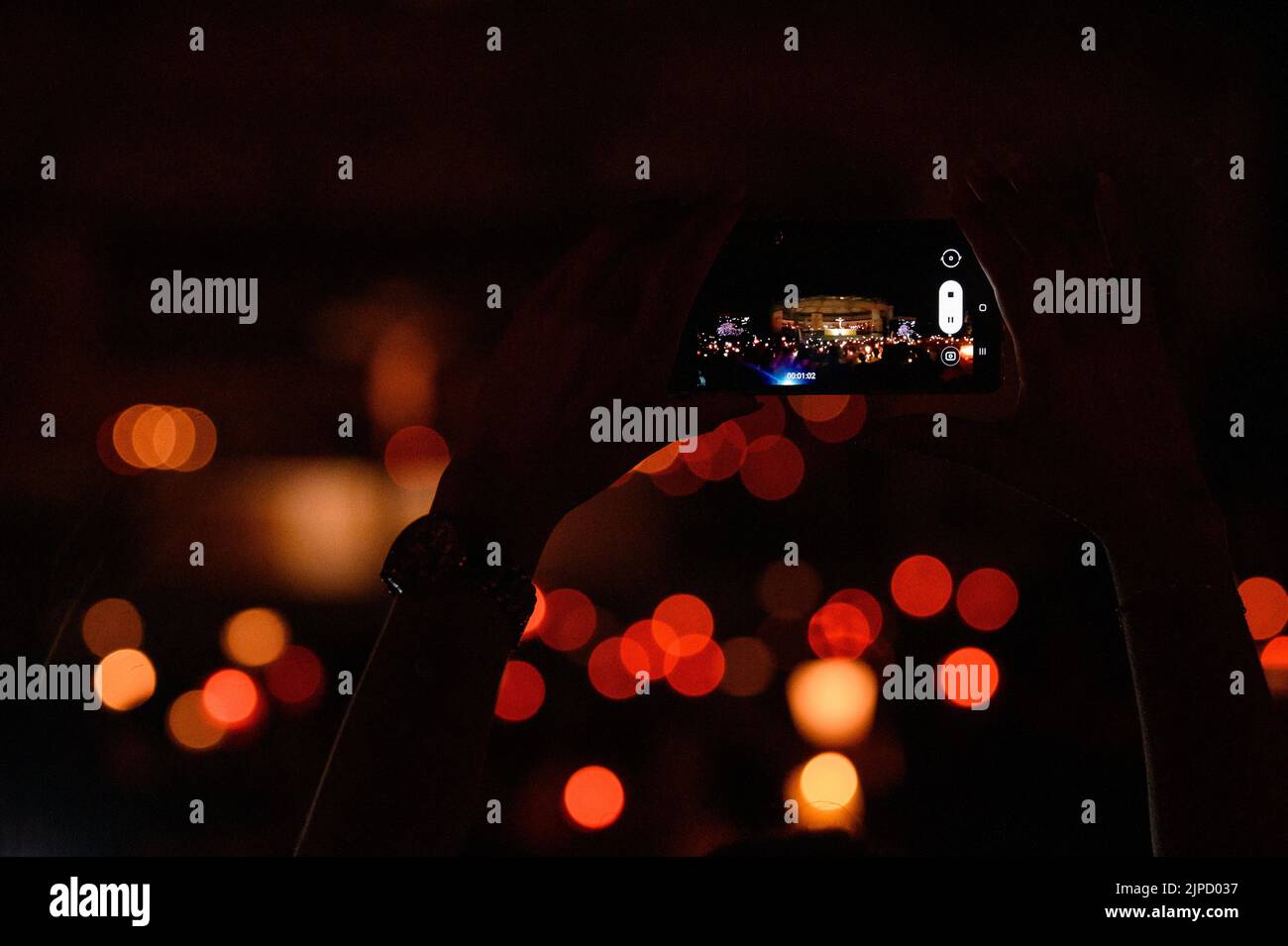 Quelqu'un prenant une photo avec un téléphone pendant la vénération de la Sainte Croix après la Messe pendant Mladifest (Festival de la Jeunesse) à Medjugorje. Banque D'Images
