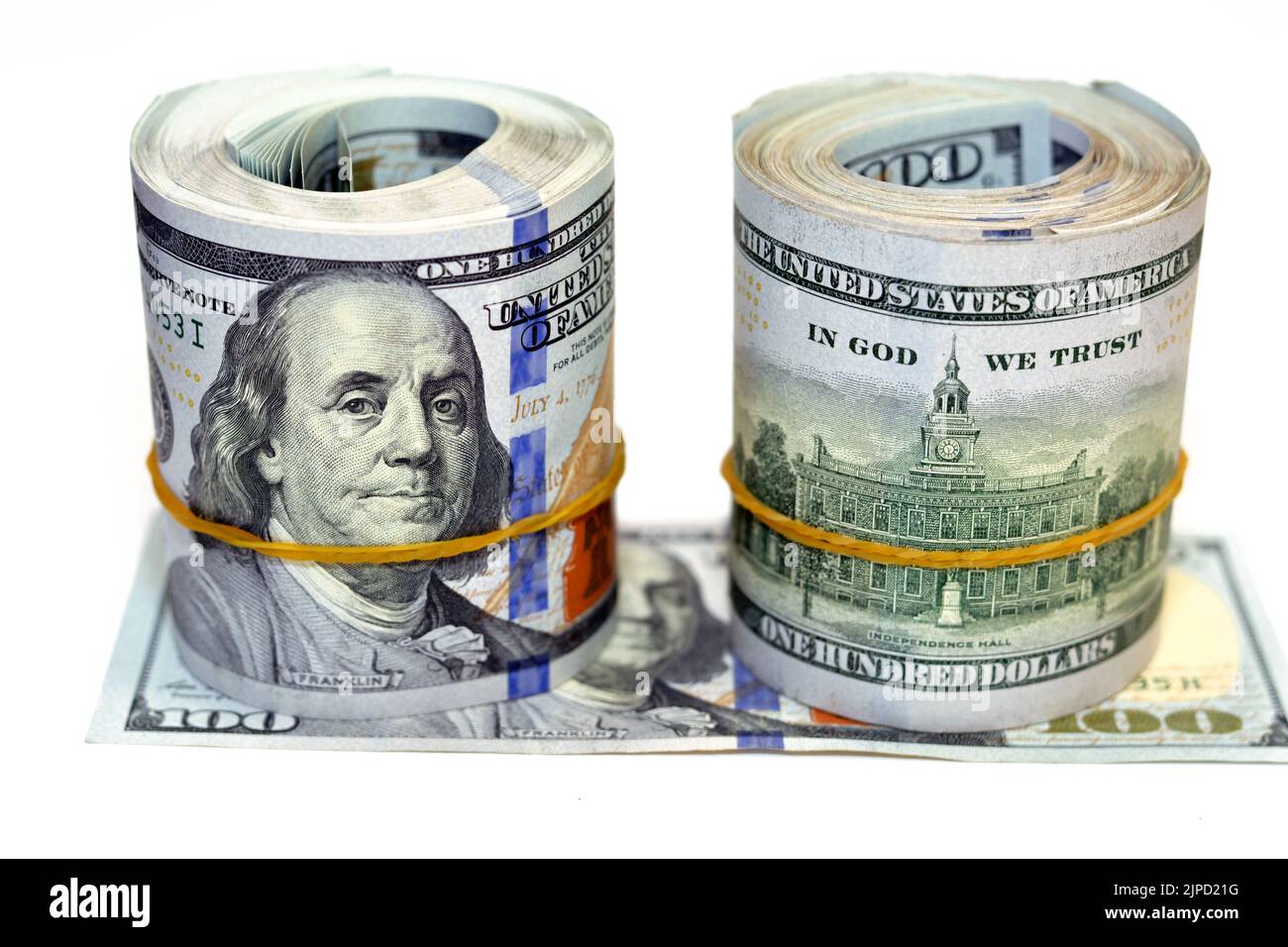Paquets de rouleaux d'argent de dollars isolés sur fond blanc, pile de cent dollars US cash billets roulés avec des bandes de caoutchouc avec l'esprit Banque D'Images