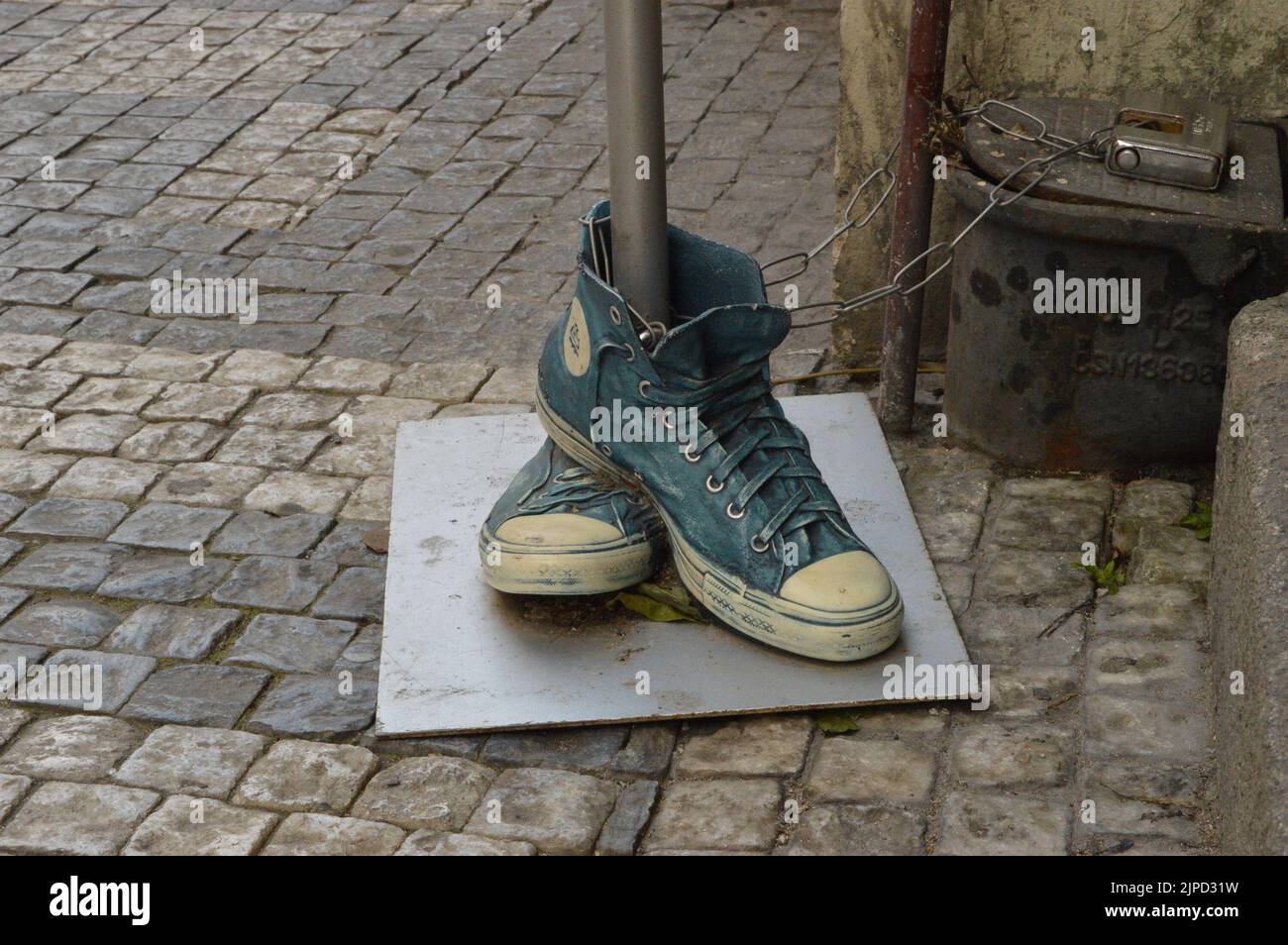 Reproduction artistique des chaussures Converse bleues dans la rue. Banque D'Images