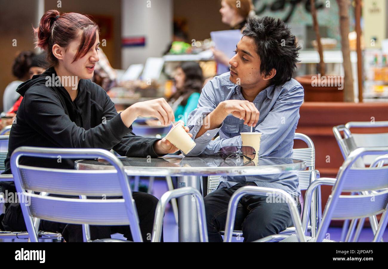 Adolescents, une opinion différente. Des amis de l'école bavardent autour d'un café dans leur cantine d'université. À partir d'une série d'images associées. Banque D'Images