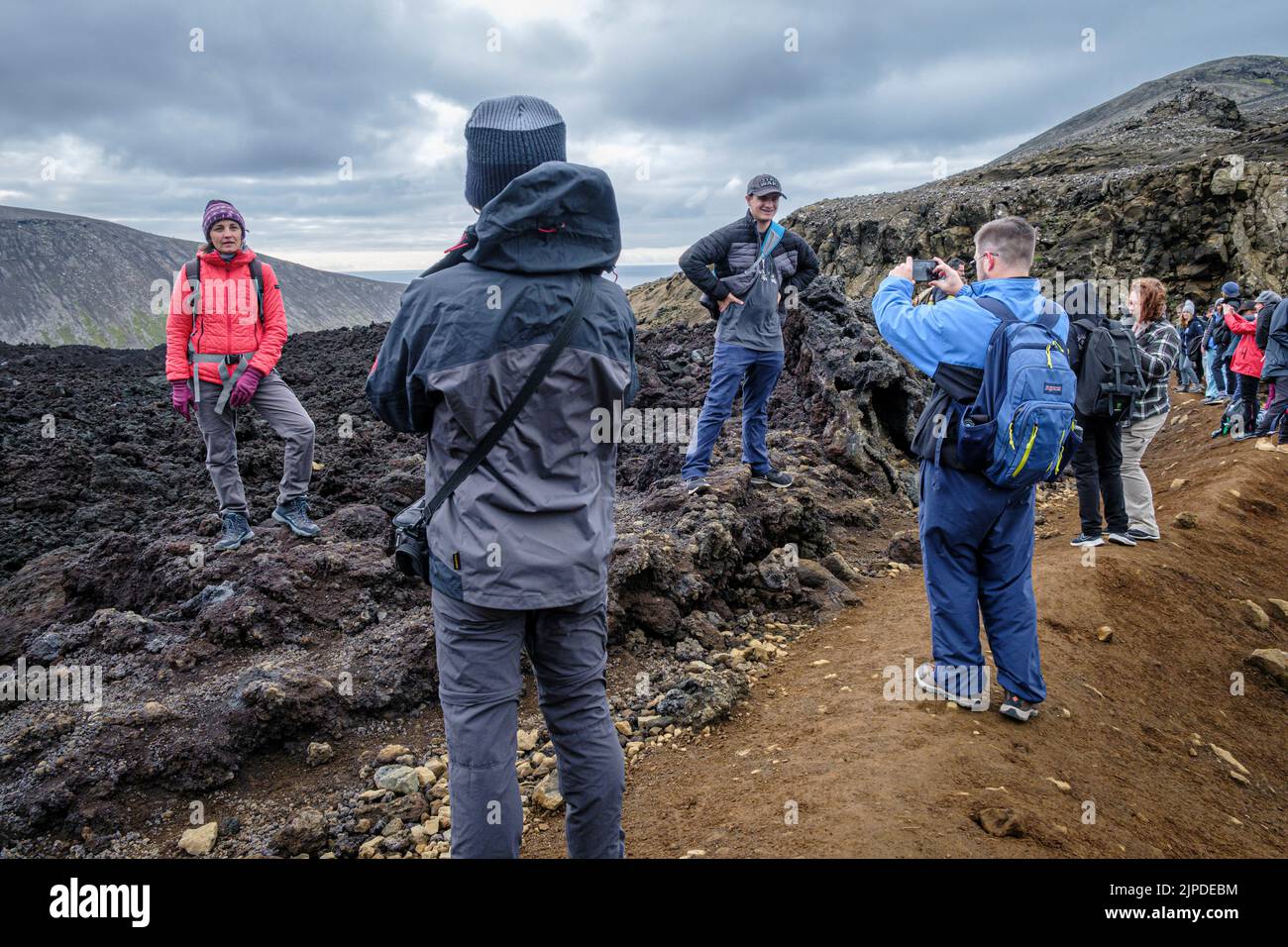Les randonneurs sur le sentier pour voir l'éruption du volcan islandais Meradalir en août 2022 s'arrêtent pour prendre des photos sur l'ancien champ de lave Banque D'Images Les randonneurs sur le sentier pour voir l'éruption du volcan islandais Meradalir en août 2022 s'arrêtent pour prendre des photos sur l'ancien champ de lave Banque D'Images