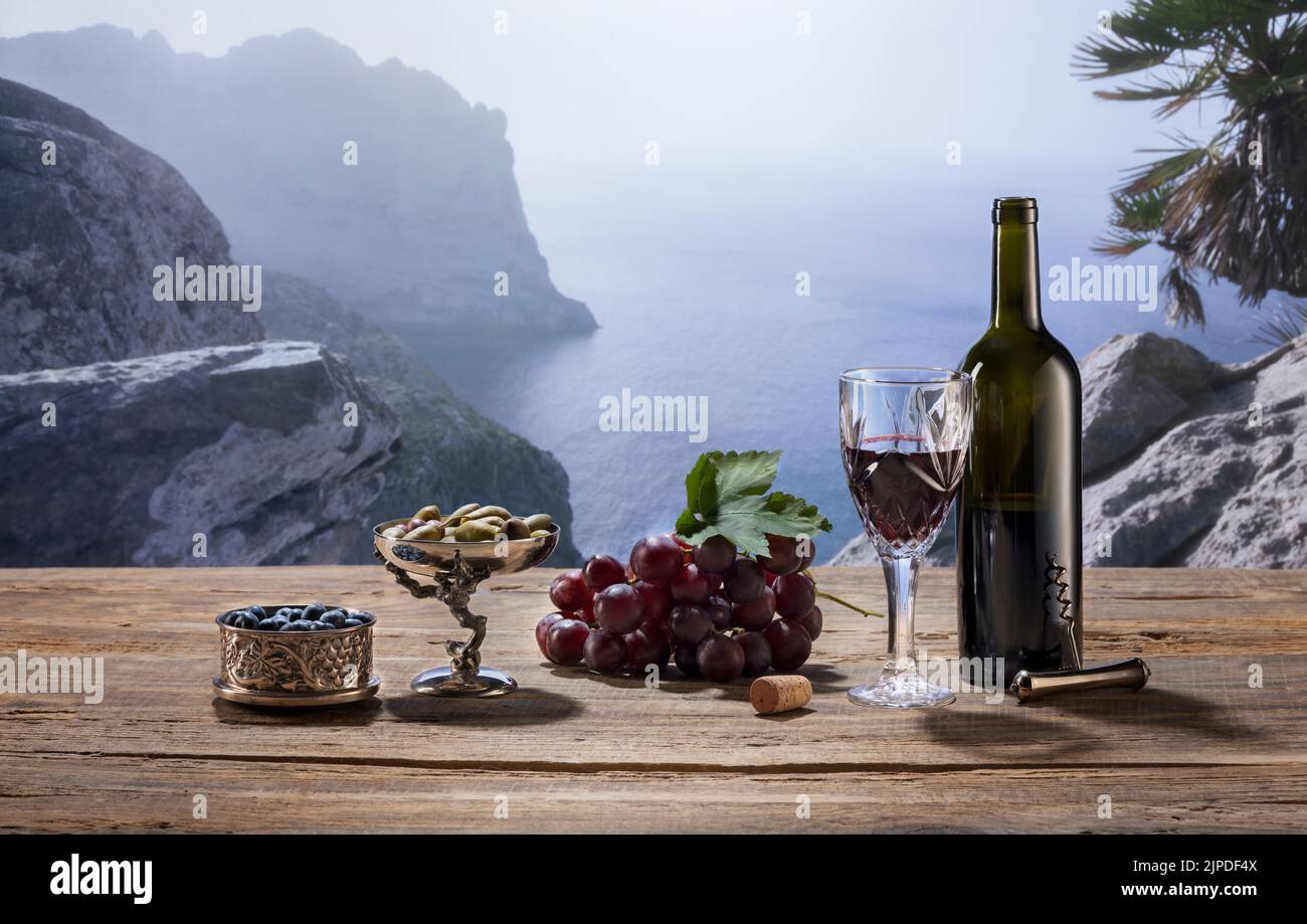 Bouteille et verre de délicieux vin semi-sec sur une table en bois isolée sur un magnifique paysage de montagne brumeux Banque D'Images