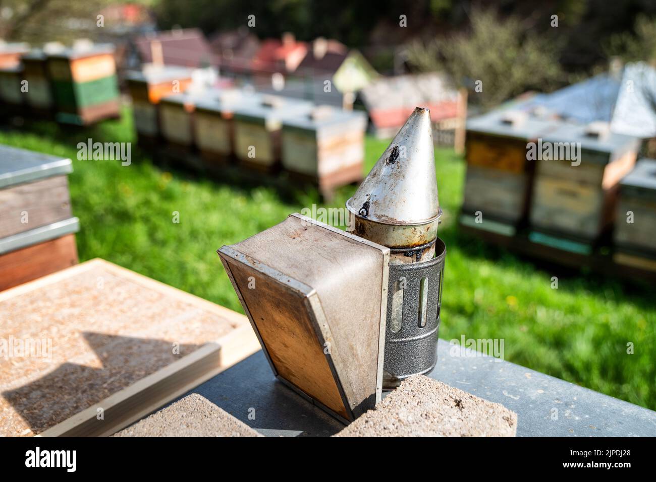 Fumeur d'abeilles et ruches à l'arrière-plan. Ruelle Banque D'Images