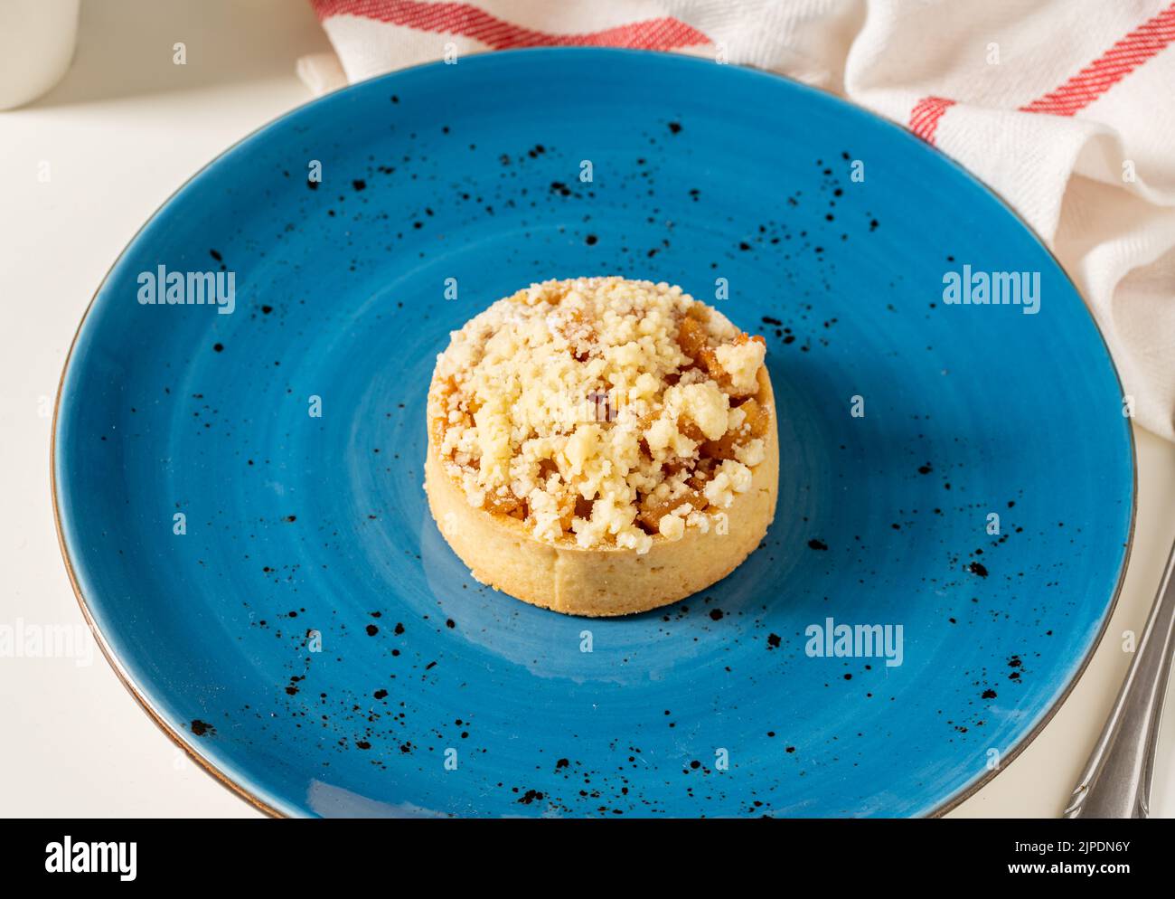 Tarte aux pommes fraîchement cuite en une seule portion sur une assiette en porcelaine bleue Banque D'Images