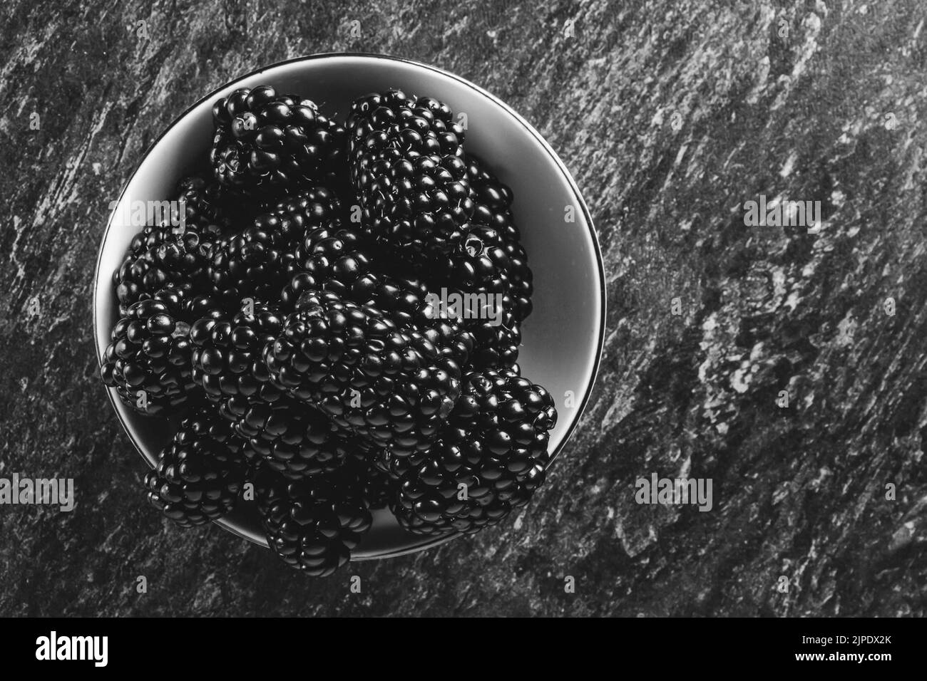 Baies BlackBerry. Baies noires en gros plan sur une surface en bois. Les fruits d'été sont dispersés sur la table. CopySpace. Banque D'Images