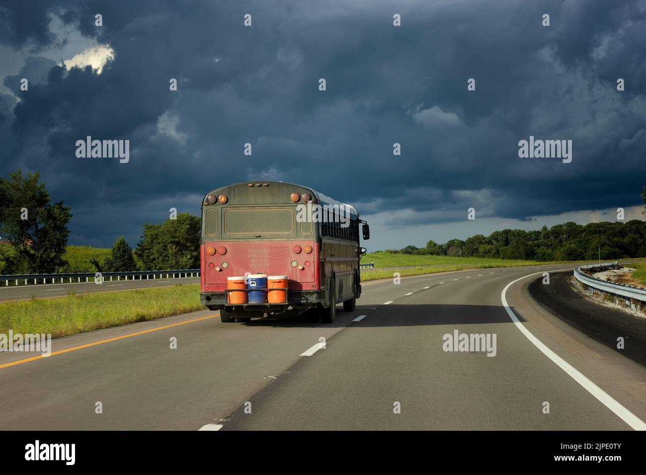 Tourné à travers un pare-brise un bus de camping, voyage l'autoroute dans le Tennessee rural vers les nuages sombres de tempête. Banque D'Images