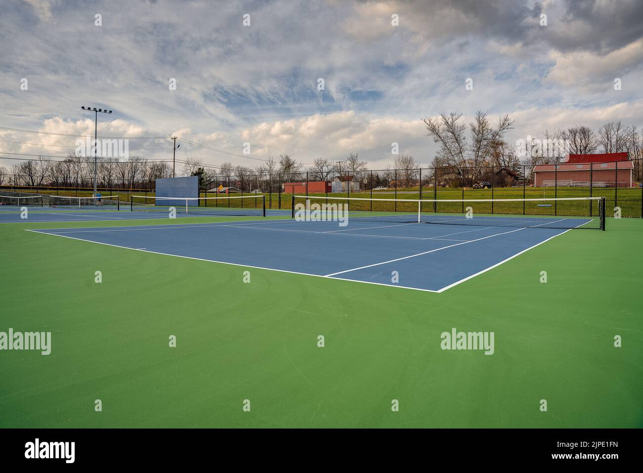 Nouveaux courts de tennis bleus extérieurs avec lignes blanches et lignes de pickleball bleu clair. Banque D'Images